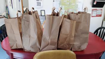 paper bags of produce labeled Ag, PIerce, Domes, J Street, Sunwise to be distributed to the campus co-ops 